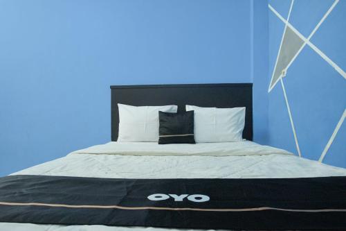 a bed with an omo blanket on top of it at Hotel O Palembang near Palembang Indah Mall formerly Hotel Relasi in Palembang