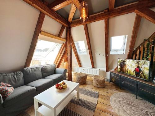 a living room with a couch and a tv at Dornröschen-Loft in Marienberg