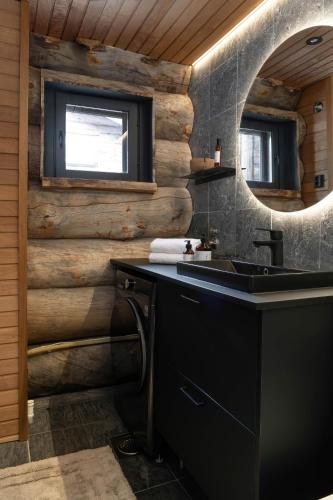 a bathroom with a black sink and a mirror at Nilirakka - Luxury log Chalet in Levi in Levi
