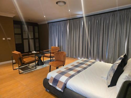 a bedroom with a bed and a table and chairs at Stone Home in Gaborone