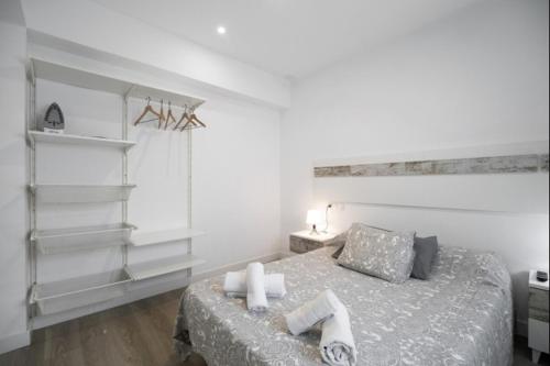 Schlafzimmer mit einem Bett mit weißen Wänden und Regalen in der Unterkunft La Terraza by Staycare in Rota