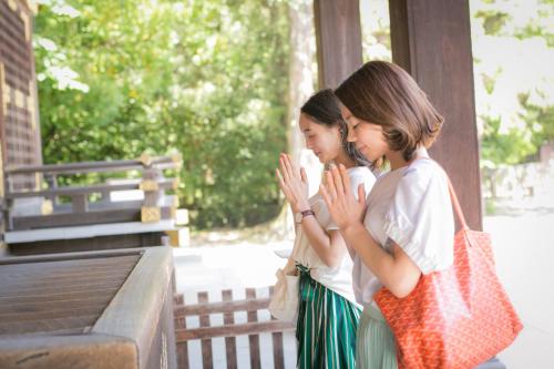 two young girls are clapping in front of a bench at Hotel Gee Haive in Mishima