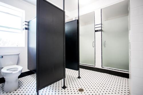 a bathroom with a toilet and a glass shower stall at American Hotel in Los Angeles