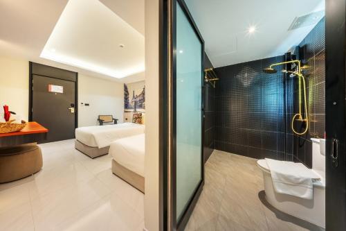a bathroom with a shower and a bedroom with a bed at U TOR Yaowarat in Bangkok