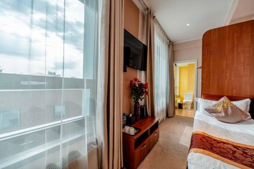 a hotel room with a bed and a large window at H9 Hotel Nine Ulaanbaatar in Ulaanbaatar
