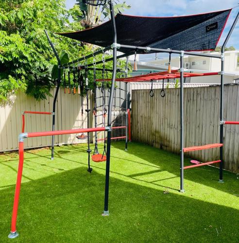 a playground with a batting cage and a swing at Renovated Family Beach House, Walk to Sand in Cabarita Beach