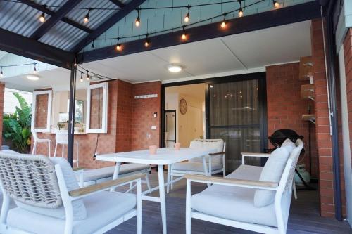 a white table and chairs on a patio at Renovated Family Beach House, Walk to Sand in Cabarita Beach