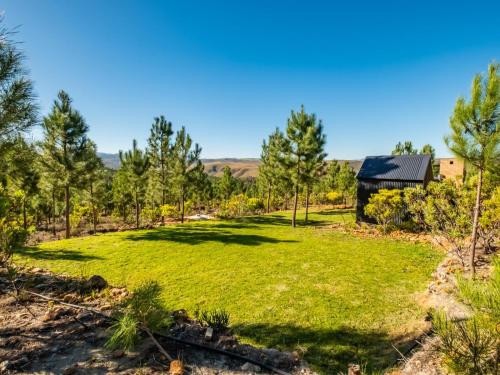 a large grassy yard with a barn in the background at Bumbrah Camp and Glamp in Houhoek