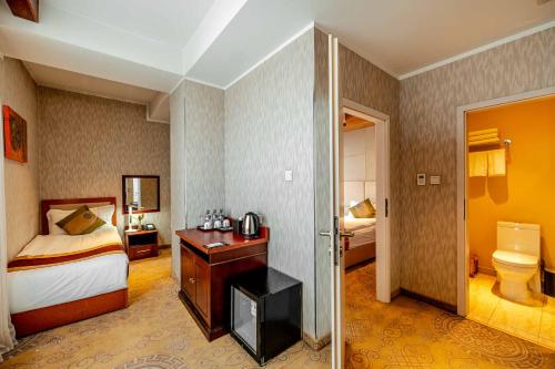 a hotel room with a bed and a bathroom at H9 Hotel Nine Ulaanbaatar in Ulaanbaatar