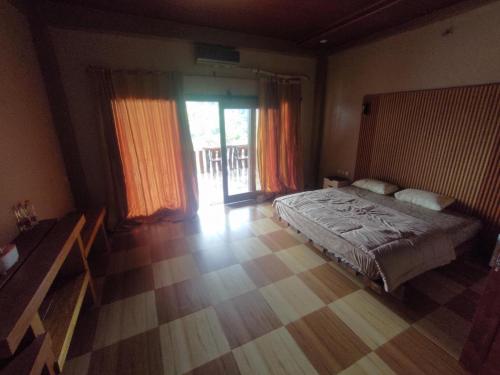 a bedroom with a bed and a wooden floor at Senaru Lodge in Senaru