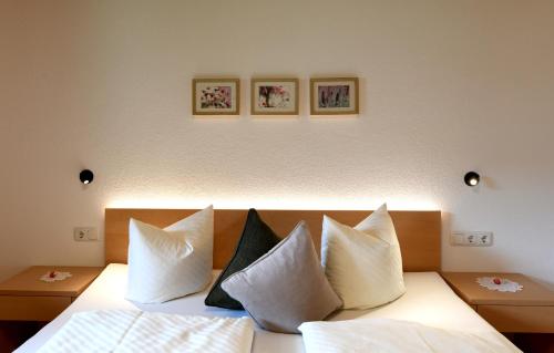 a bedroom with a bed with white sheets and pillows at Ferienwohnung Lingg in Schoppernau