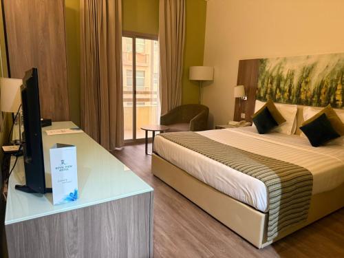 a hotel room with a bed and a tv at Royal View Hotel in Ras al Khaimah