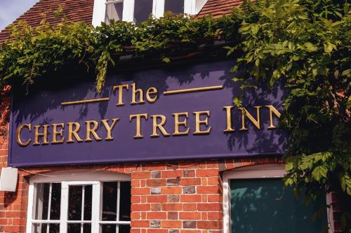 a sign for the cherry tree inn on a brick building at The Cherry Tree Inn in Nuffield
