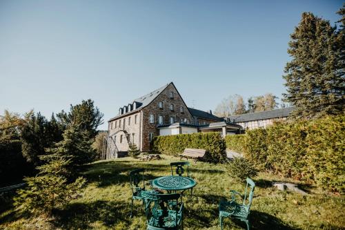 a yard with a table and chairs in front of a building at Sonnenhotel Hoher Hahn in Schwarzenberg