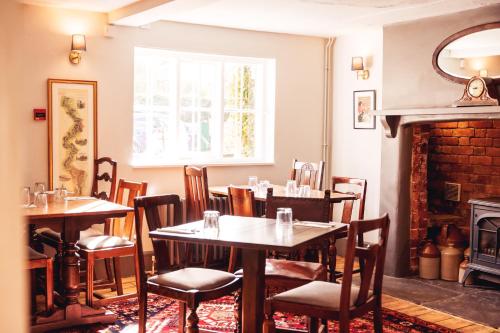 a dining room with tables and chairs and a fireplace at The Cherry Tree Inn in Nuffield