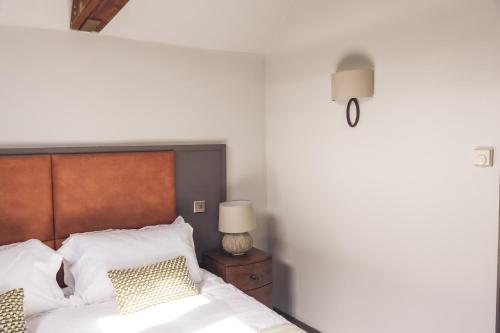 a bedroom with a bed with white sheets and pillows at The Cherry Tree Inn in Nuffield