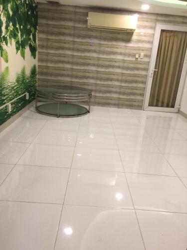 a room with a glass table on a white tile floor at Myfriend Hostel in Ho Chi Minh City