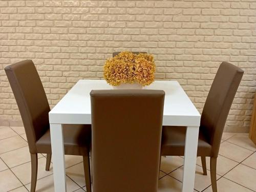 a white table with chairs and a vase of flowers at Appartamenti Castel Ritaldi Il Sagrantino in Bruna