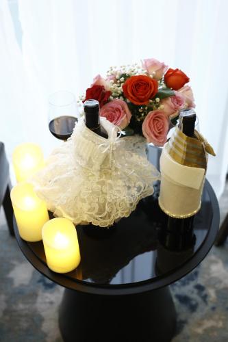 a table with a bouquet of roses and candles at Songlam Waterfront Hotel - 藍江酒店 in Ha Tinh