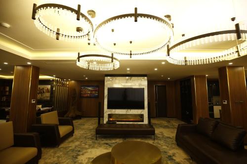 a living room with a television and chandeliers at Songlam Waterfront Hotel - 藍江酒店 in Ha Tinh