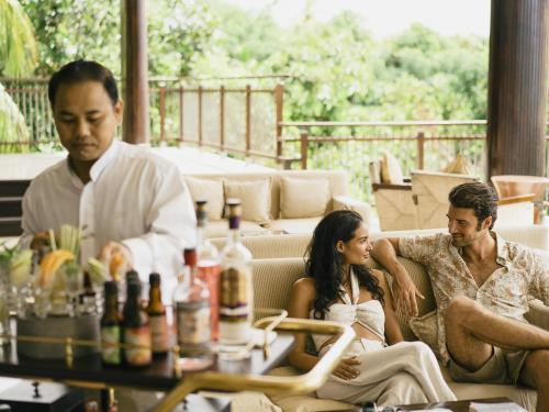a man and a woman sitting on a couch at Raffles Seychelles in Baie Sainte Anne