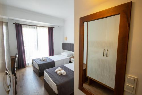 a hotel room with two beds and a mirror at TURUNÇ DREAM HOTEL in Mugla