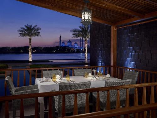 a table on a balcony with a view of the water at Fairmont Bab Al Bahr in Abu Dhabi