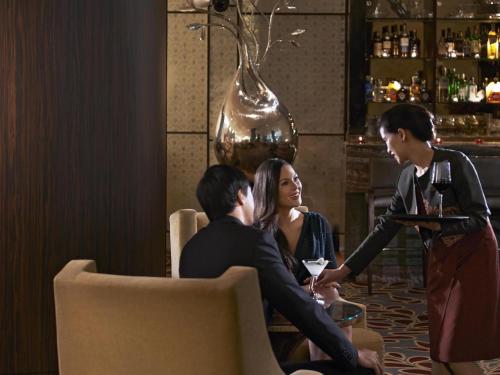 a group of people sitting at a table in a bar at Raffles Makati in Manila