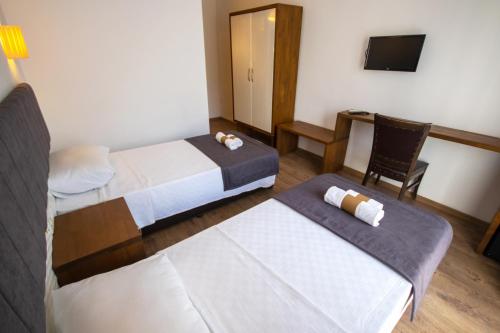 a hotel room with two beds and a desk at TURUNÇ DREAM HOTEL in Mugla