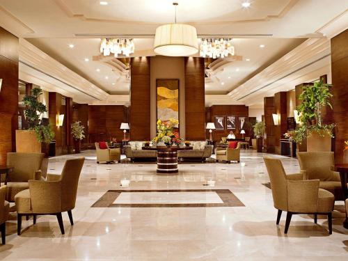 a lobby of a hotel with chairs and a table at Raffles Makkah Palace in Makkah