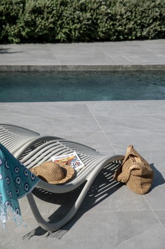 a lounge chair with a towel and a book on it at Melidonia Suites in Akrotiri