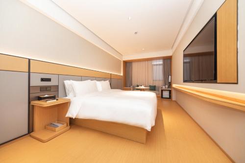 a bedroom with a large bed and a tv at JI Hotel Shanghai Caohejing Caobao Road in Shanghai