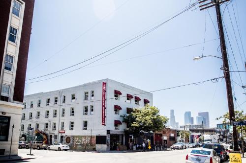 a white building on a city street with cars parked at American Hotel in Los Angeles