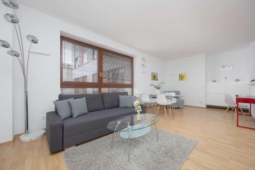 a living room with a couch and a glass table at Spacious and Bright Apartment with Parking in the City Center by Noclegi Renters in Warsaw