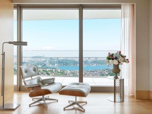 a living room with a chair and a window with a view at Raffles Istanbul in Istanbul