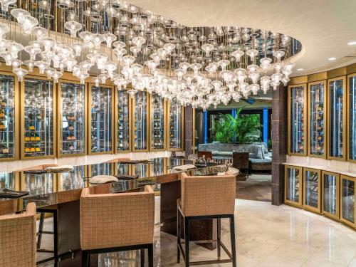 a restaurant with a chandelier and tables and chairs at Raffles Istanbul in Istanbul