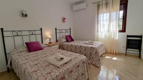 2 Betten in einem Schlafzimmer mit lila Kissen in der Unterkunft Villa 62 by Villamya in El Gastor