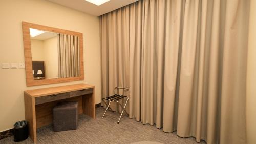 a room with a vanity and a mirror and a curtain at بنزرت للشقق المخدومة in Al Hofuf