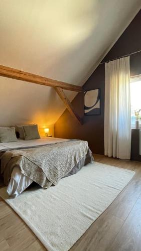 a bedroom with a large bed with a white rug at A la Petite Grange in Obenheim