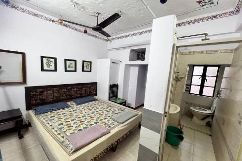 a bedroom with a bed and a shower and a toilet at Nukkad Guest House Near Lake Pichola in Udaipur