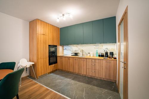 a kitchen with wooden cabinets and a counter top at TRINAVIS Boutique Apartments, OWN PRIVATE PARKING, City Center, Entire Apartment in Veliko Tŭrnovo