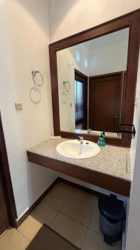 a bathroom with a sink and a large mirror at Schonen House by Ruby Living in Yogyakarta