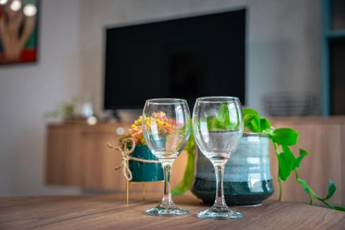 two wine glasses sitting on top of a table at TRINAVIS Boutique Apartments, OWN PRIVATE PARKING, City Center, Entire Apartment in Veliko Tŭrnovo
