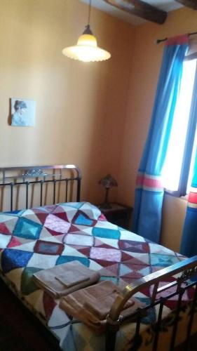 a bedroom with a bed with a colorful quilt on it at Casa Rural Hoces del Duratón El Villar in Villar de Sobrepeña