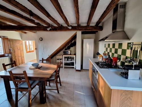 a kitchen with a wooden table and a kitchen counters at Can Pedragos in Sales del Llierca