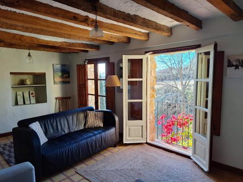a living room with a couch and a sliding glass door at Can Pedragos in Sales del Llierca