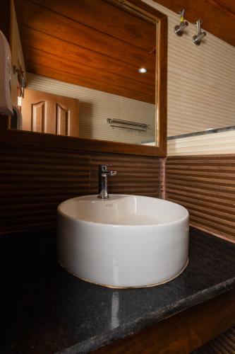 a white sink in a bathroom with a mirror at Sumitel Queens Yard in Darjeeling