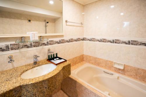 a bathroom with a sink and a bath tub at Bukit Merah Laketown Resort in Taiping
