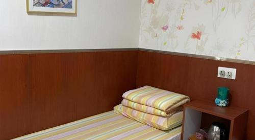 a small room with a bed and a wooden wall at New Mong Kok Guest House in Hong Kong