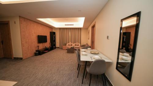 a hotel room with a long table and chairs at بنزرت للشقق المخدومة in Al Hofuf